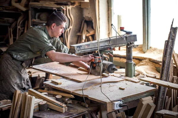 Een man werkt op de machine met het houten product — Stockfoto