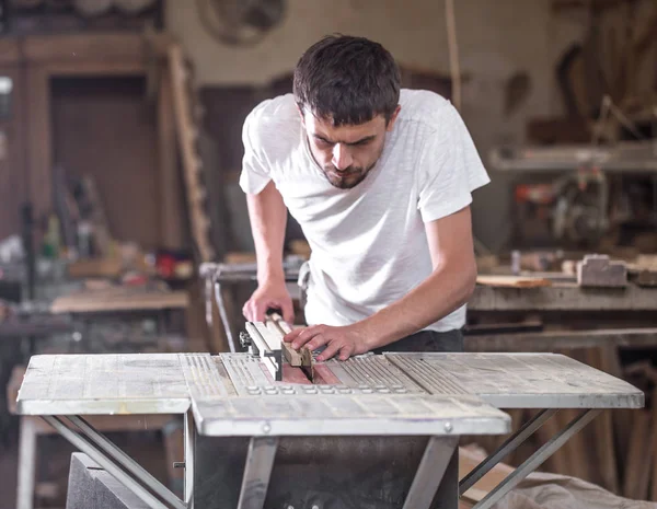 Un uomo lavora sulla macchina con il prodotto in legno — Foto Stock