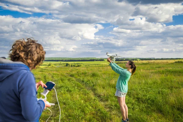 Hermosa chica en un campo lanza el dron en el cielo — Foto de Stock