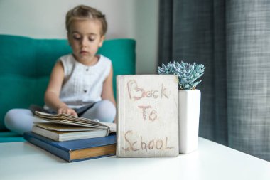 elinde bir kitapla geri okula oturan kız