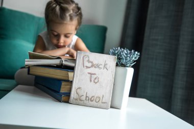 elinde bir kitapla geri okula oturan kız