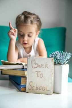 elinde bir kitapla geri okula oturan kız