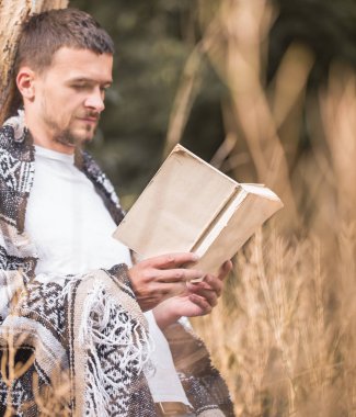 Genç adam bir kitap okuma ağaca