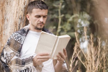 Genç adam bir kitap okuma ağaca