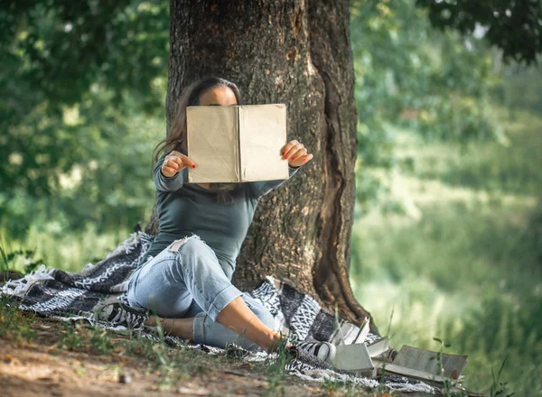 Bir ağaç bir kitap okuma yakınındaki bir genç kız — Stok fotoğraf