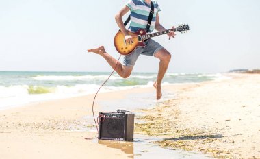 adam müzik aletleri ile sahilde