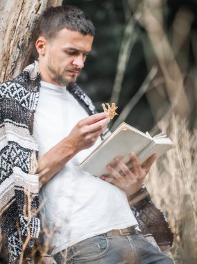 Genç adam bir kitap okuma ağaca