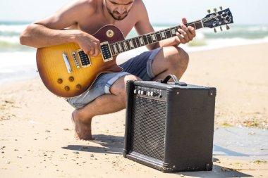 adam müzik aletleri ile sahilde