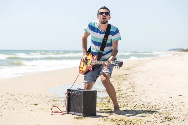 adam müzik aletleri ile sahilde