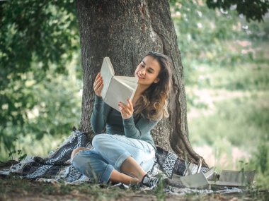 bir ağaç bir kitap okuma yakınındaki bir genç kız