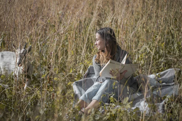 Ung flicka på ett fält som en bok — Stockfoto