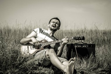 genç adam sahada, gitar ve amfi, müzik ve sanat kavramı ile müzisyen