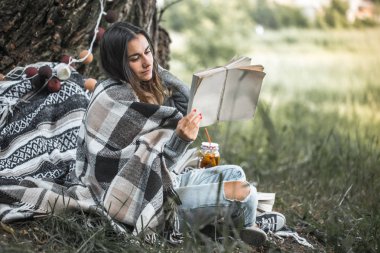 bir ağaç bir kitap okuma yakınındaki bir genç kız