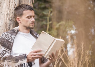 Genç adam bir kitap okuma ağaca