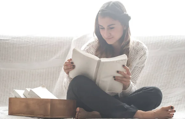 Chica leyendo libro en sofá — Foto de Stock