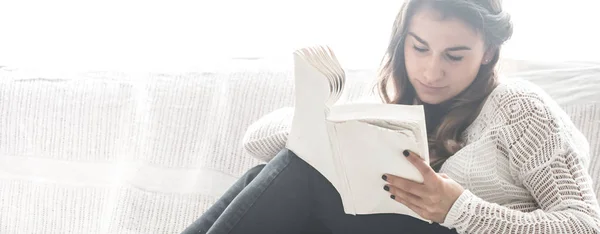 Chica leyendo libro en sofá — Foto de Stock