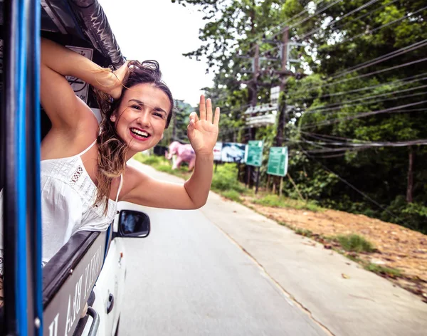 gülümseyen kız görünüyor bir taksi, pencereden dışarı tuk-Tuk