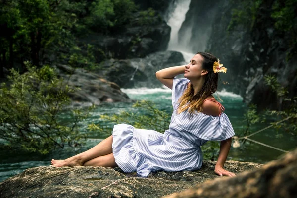 Fille assise près de la cascade — Photo