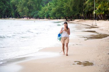 Kız telefon ile Sahilde yürüyüş