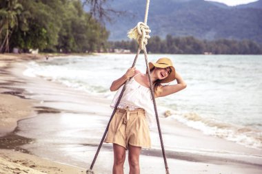 Kız Tayland beach bir salıncak üzerinde duruyor