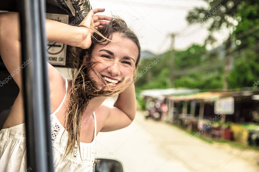 smiling girl looks out of the window of a taxi