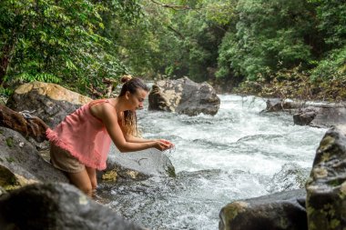 Kız bir dağ dere suyu içer