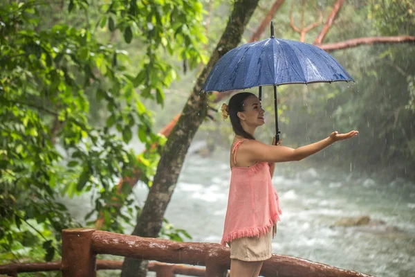 Meisje met paraplu in een regenwoud — Stockfoto