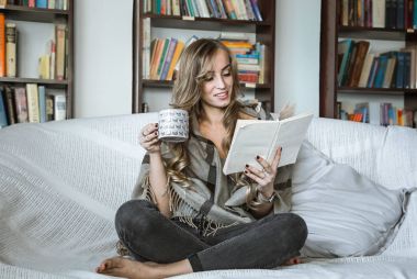 kız kanepede kitap okuma