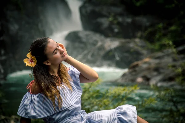 Fille assise près de la cascade — Photo