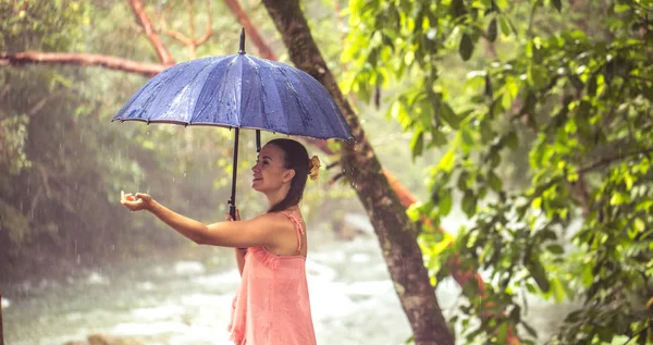 Meisje met paraplu in een regenwoud — Stockfoto