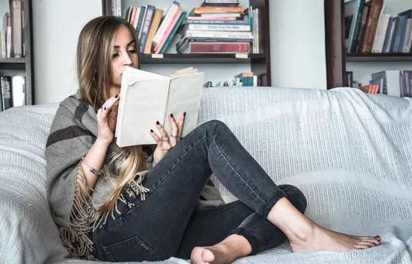 Chica leyendo libro en sofá — Foto de Stock
