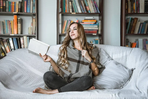 Chica leyendo libro en sofá — Foto de Stock