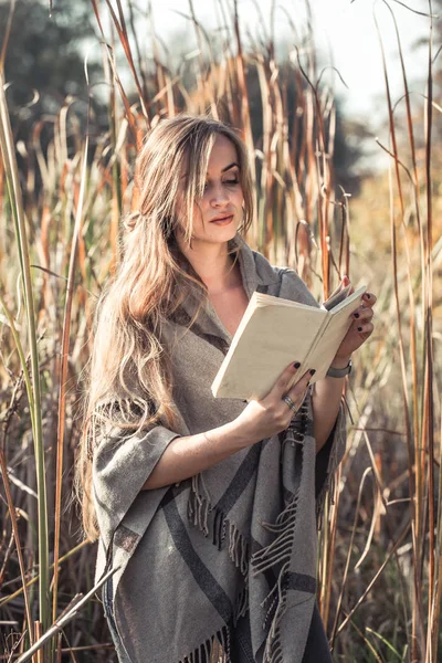 Güzel kız sonbahar ormandaki bir kitap okuma — Stok fotoğraf