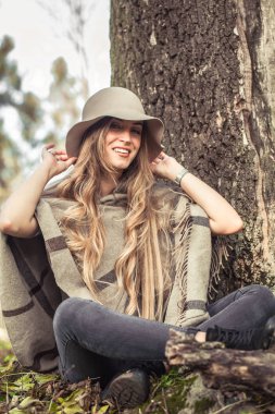 sonbahar ormandaki bir kitap okuma şapkalı kız