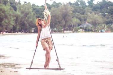 Kız Tayland beach bir salıncak üzerinde duruyor