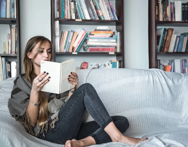 Chica leyendo libro en sofá — Foto de Stock