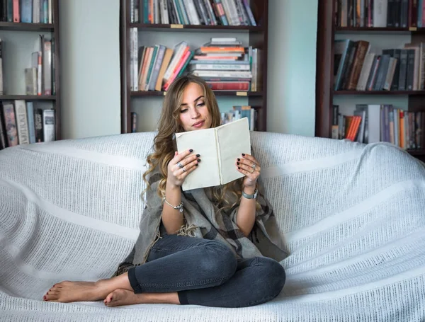 Chica leyendo libro en sofá — Foto de Stock