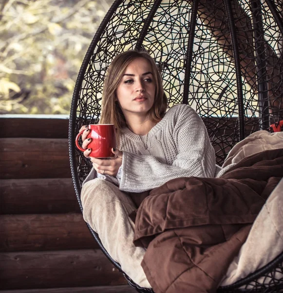 Mädchen mit einer Tasse Tee im bequemen Stuhl — Stockfoto