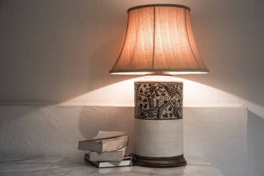 lamp with books on the table clipart