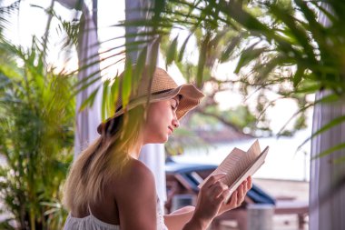 Kız sahilde bir kitap okuma