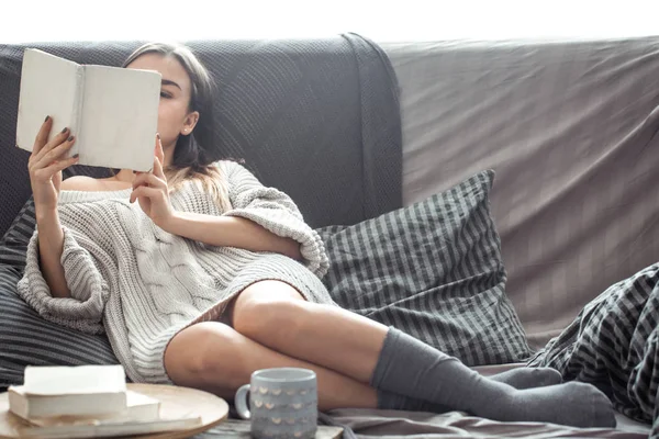 Chica leyendo libro en sofá — Foto de Stock