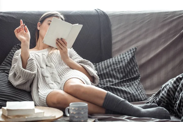 Dziewczyna czytanie książki na kanapie — Zdjęcie stockowe