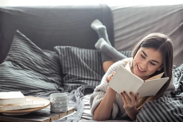 Chica leyendo libro en sofá — Foto de Stock