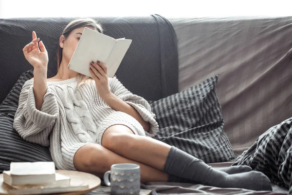 Chica leyendo libro en sofá — Foto de Stock