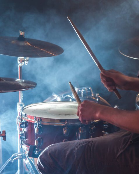man plays the drum, flash of light, a beautiful light in the background with copy space
