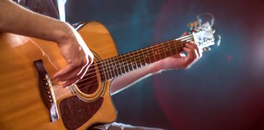 oynarken akustik gitar, yakın çekim, flaş ışıklı bir adamın elini