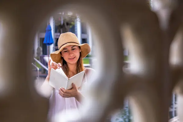 Flicka i hatt en bok på semester — Stockfoto