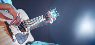 oynarken akustik gitar, yakın çekim, flaş ışıklı bir adamın elini