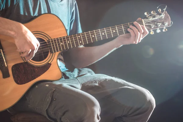 Oynarken akustik gitar, yakın çekim, flaş ışıklı bir adamın elini — Stok fotoğraf