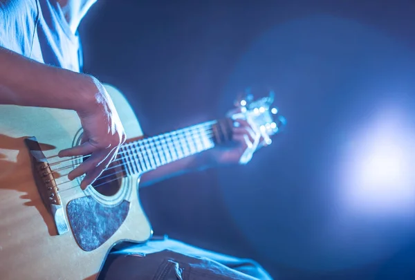 Handen på man spelar akustisk gitarr, närbild, blixt av ligh — Stockfoto